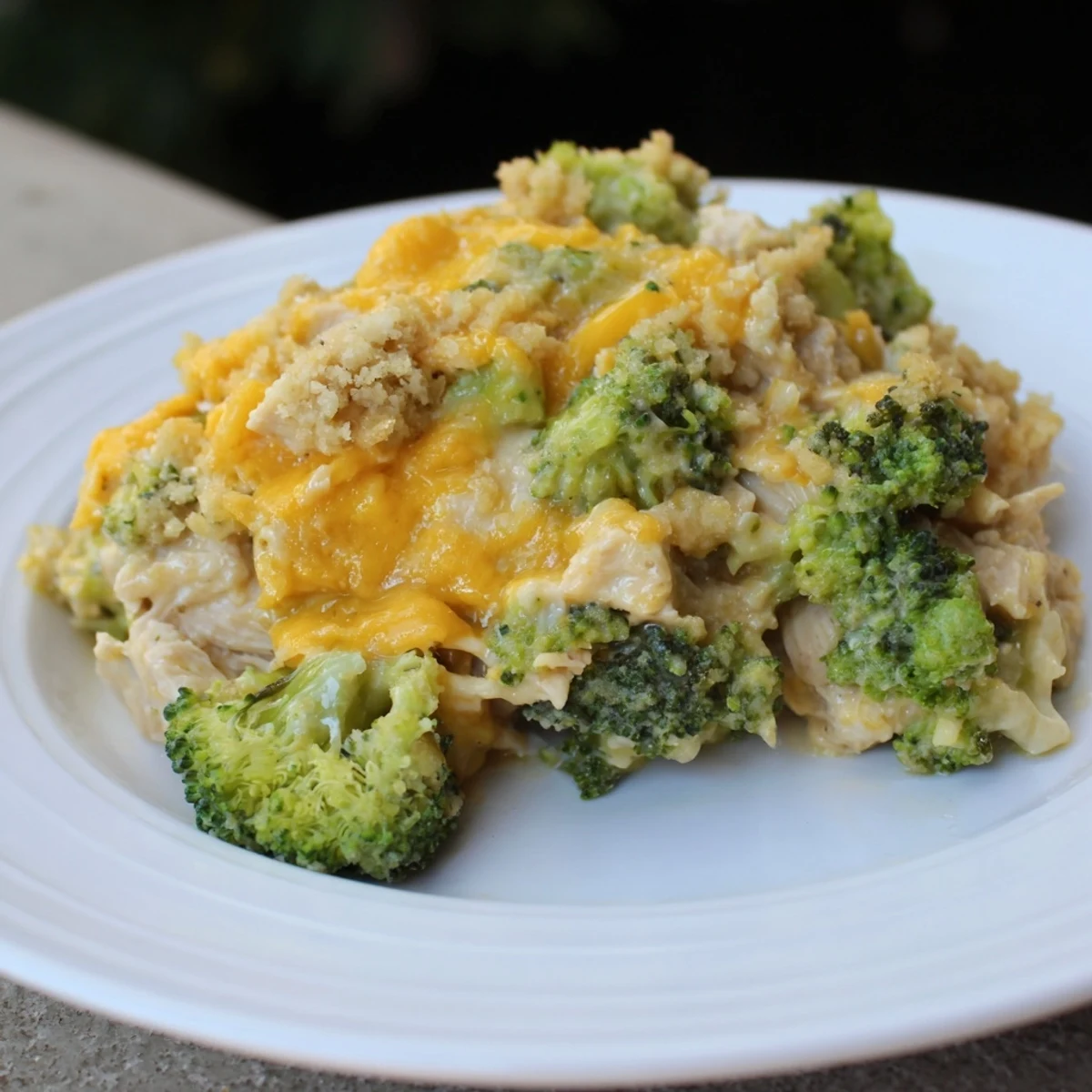 A steaming casserole of flavorful Chicken & Broccoli Cheddar Bake, topped with browned breadcrumbs.