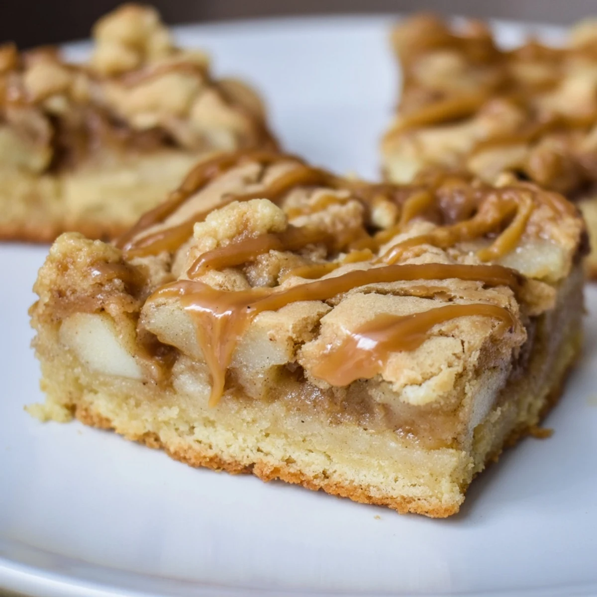 Warm, spiced diced apples peaking through rich caramel within these amazing Caramel Apple Cookie Bars.