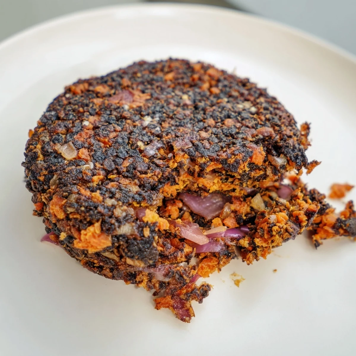 A close-up of a perfectly cooked black bean burger showcasing a crispy exterior and tender inside.