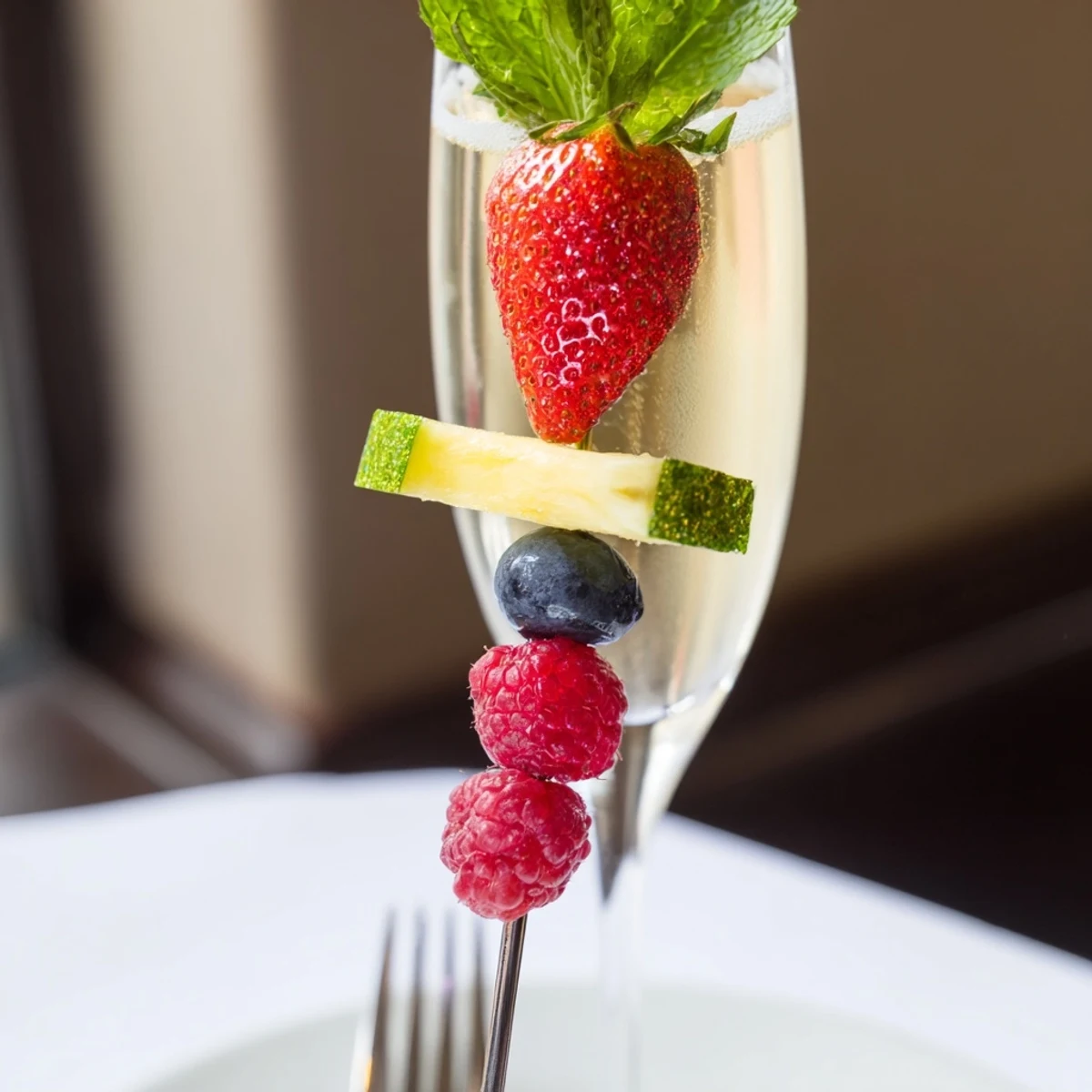 Colorful arrangement of Champagne Flute Fruit Garnishes featuring strawberries and pineapple, festive for New Year's.