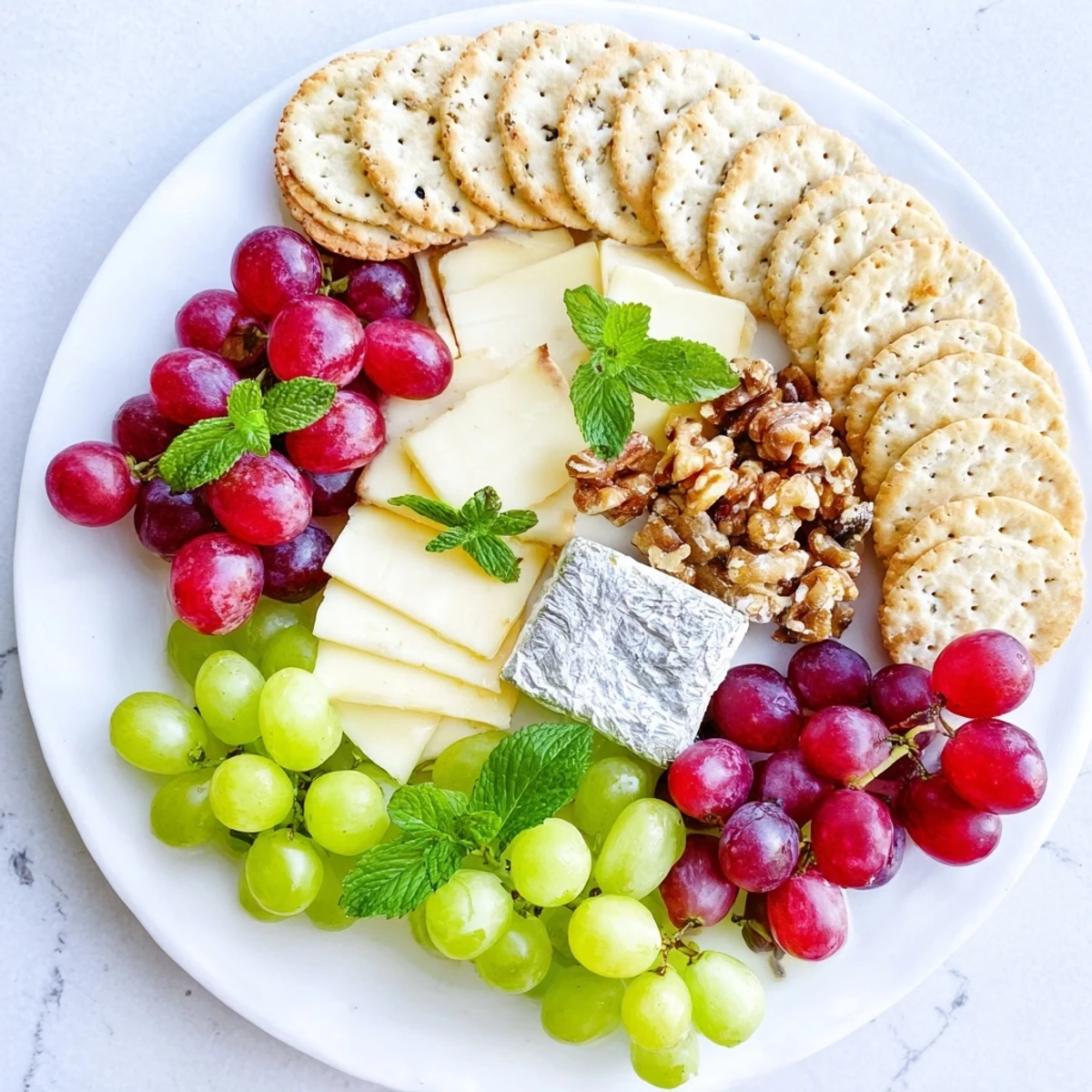 Sparkling Grape and Silver Cracker Platter, a beautiful appetizer, showcases red and green grapes alongside creamy brie.