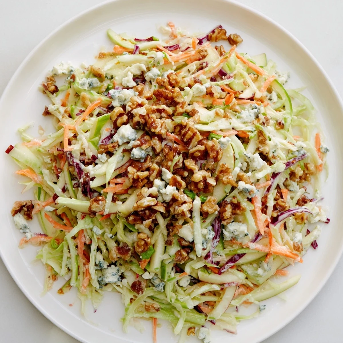 A colorful Crunchy Apple & Walnut Slaw with creamy blue cheese, perfect summer salad.