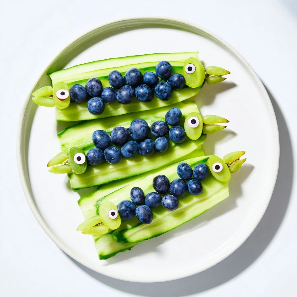 Vibrant Peacock Tail appetizer, featuring crisp cucumber slices and juicy grapes artistically arranged.