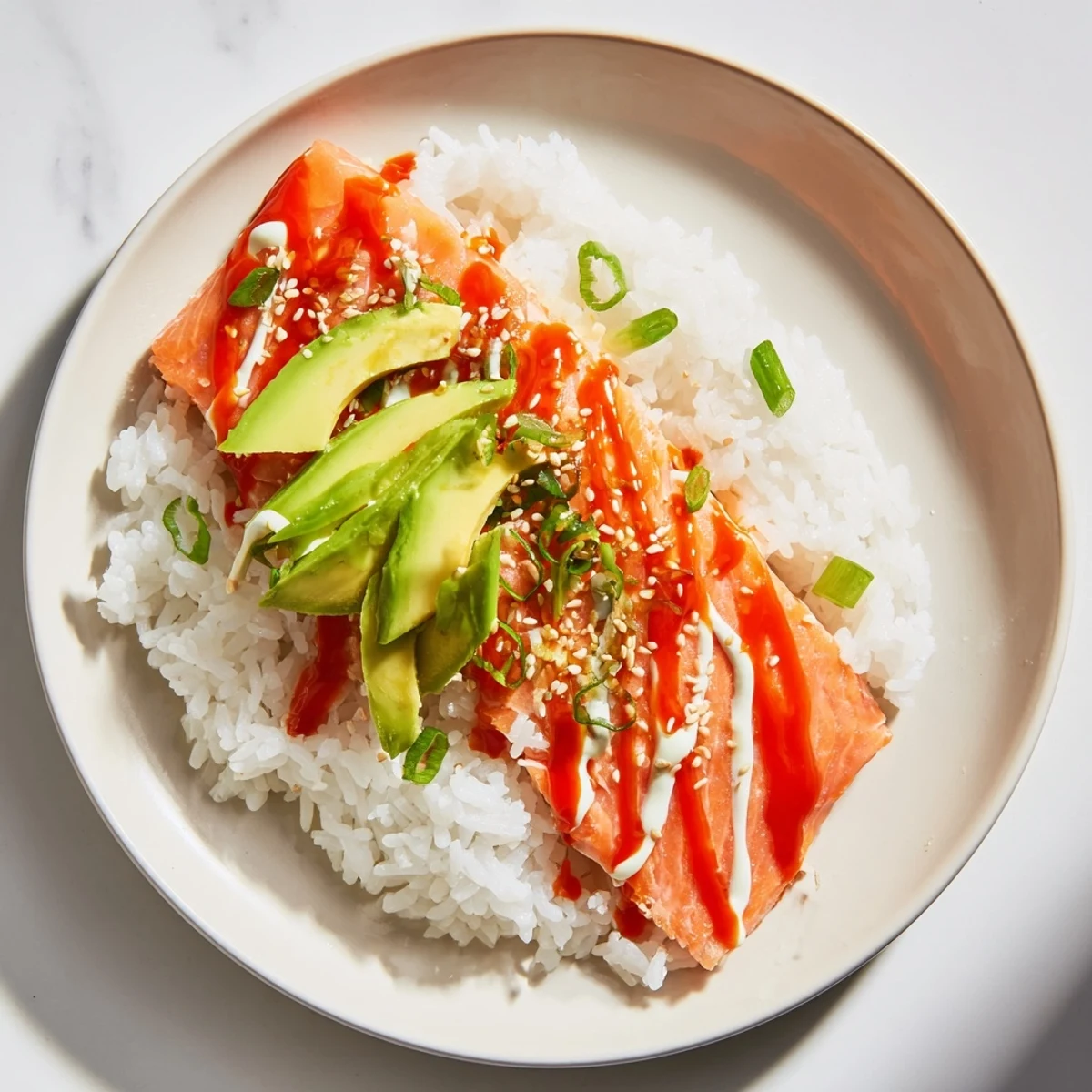 Flaked salmon and rice with seaweed: A beautiful Classic Salmon Rice bowl topped with avocado and sesame seeds.