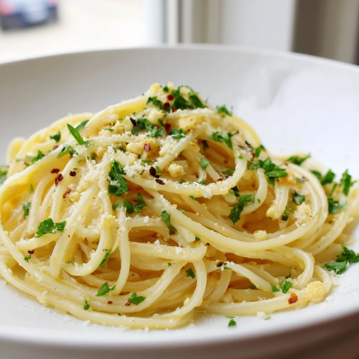 Golden, glistening garlic butter linguine with fresh parsley, ready for a delicious Italian meal.