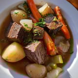 Close-up of a bubbling Irish Beef Stew, with chunks of beef and carrots visible, savory aroma.