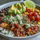 Easy salsa chicken bowls served over rice with avocado, tomatoes, and a squeeze of lime for a fresh, hearty meal.  