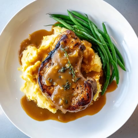 A flavorful Pork Chops & Cheddar Mash Bowl showcases juicy pork with rich, creamy mashed potatoes.