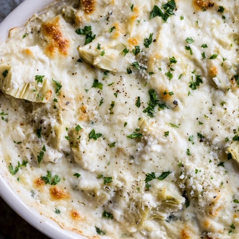 Warm and bubbly baked artichoke dip, a crowd-pleasing appetizer with creamy textures and cheesy topping.