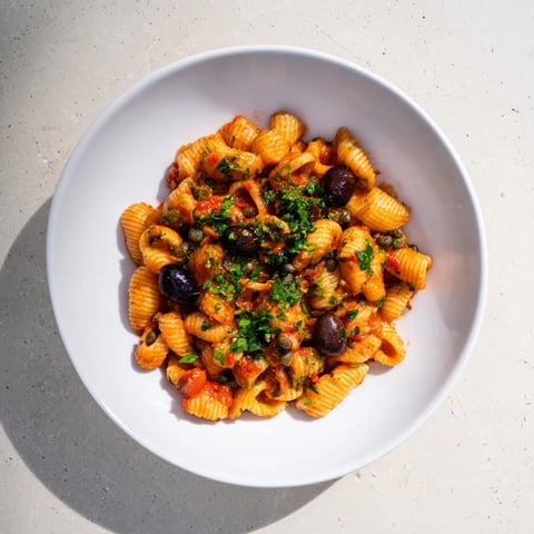 Steaming Puttanesca Ditalini, a flavorful Italian pasta dish with olives, capers, and tomatoes.