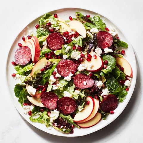Vibrant Hot Girl Christmas Salad, tossed and ready to eat with salami, greens, and cheese.