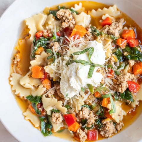Steaming bowl of Healthy Lasagna Soup with melted cheese and fresh herbs, ready to savor.
