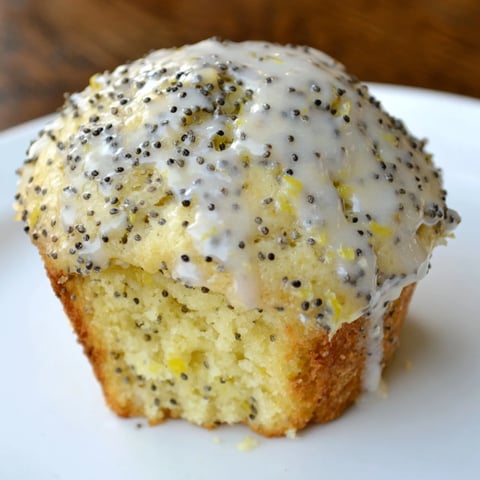 Golden, baked Lemon Poppy Seed Muffins with a simple lemon glaze, promising a zesty, delightful bite.