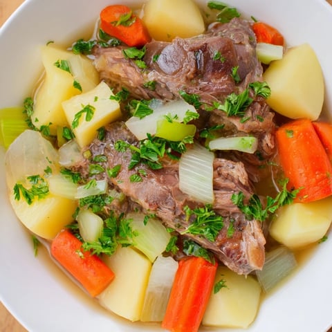 Hearty Welsh Cawl stew steams in a rustic pot, boasting fall-apart lamb and root vegetables.