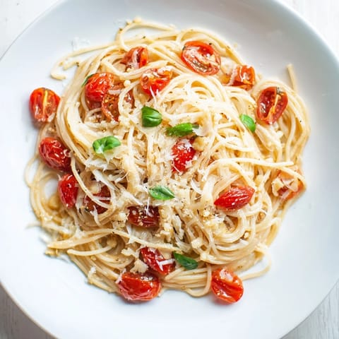 Close-up of a skillet brimming with Lazy-Girl Pasta, showcasing the silky, tomato-infused sauce and garlic.