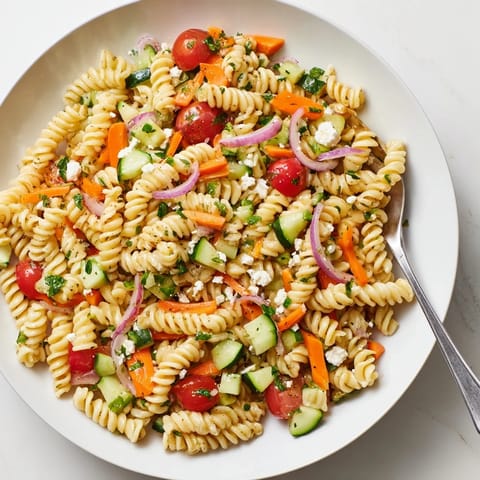 A refreshing bowl of pasta salad with colorful vegetables, ready to enjoy at a picnic.