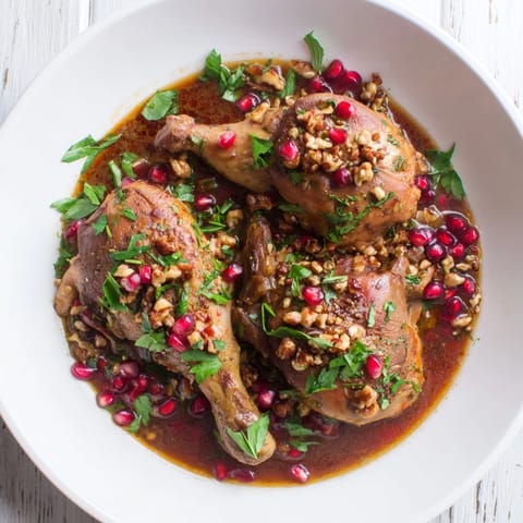 A flavorful Persian Pomegranate Walnut Fesenjan Stew, garnished with fresh herbs, ready to serve.