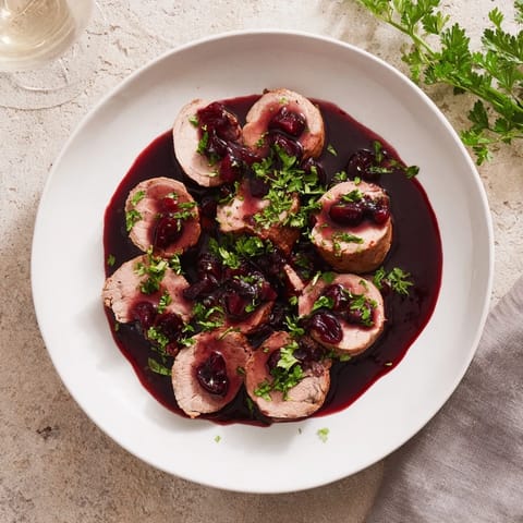 This perfectly roasted tart cherry date glazed pork tenderloin is ready to be sliced and served.