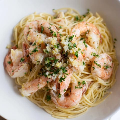 Tender shrimp and angel hair pasta glistening in a flavorful one-skillet Lemon Garlic Shrimp dish.