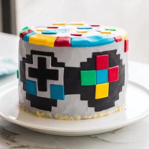 Enjoy this nostalgic Pixel Video Game Controller Cake, featuring delicious vanilla cake and buttercream frosting.