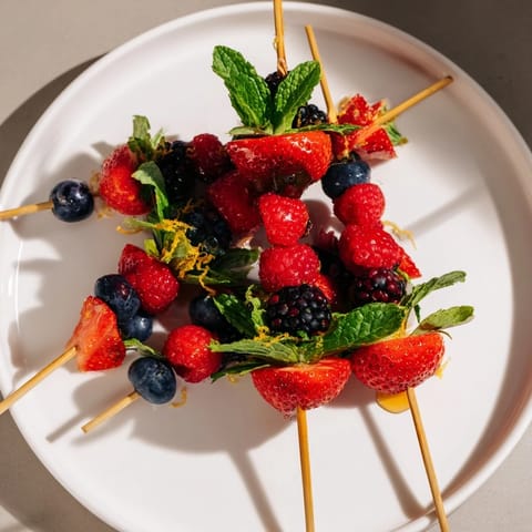 Fresh fruit skewers with strawberries, blueberries, and blackberries, a quick and healthy treat visualized.