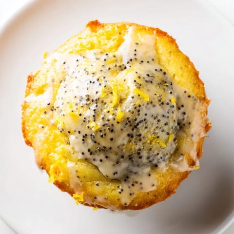 Textured close-up of tender Lemon Poppy Seed Muffins, showing crunchy poppy seeds and moist crumb, ready to eat.
