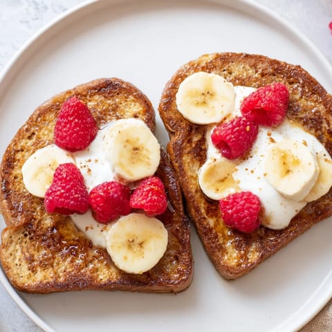 A plate of custardy Protein French Toast, cooked perfectly, ready to be enjoyed with maple syrup.