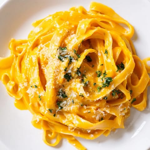 Velvety roasted butternut squash sauce coats strands of fettuccine, with golden squash cubes and garlic on the side.
