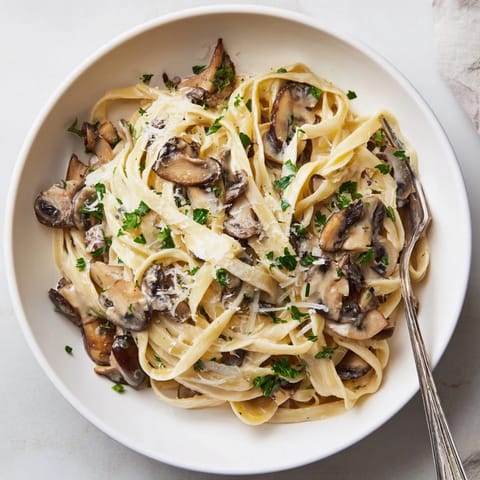 A close-up of Creamy Mushroom Linguine in a white bowl, highlighting golden-brown mushrooms and glistening sauce for an inviting weeknight meal.  