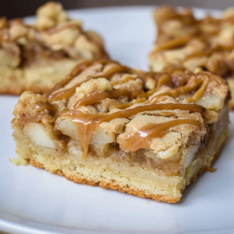 Warm, spiced diced apples peaking through rich caramel within these amazing Caramel Apple Cookie Bars.