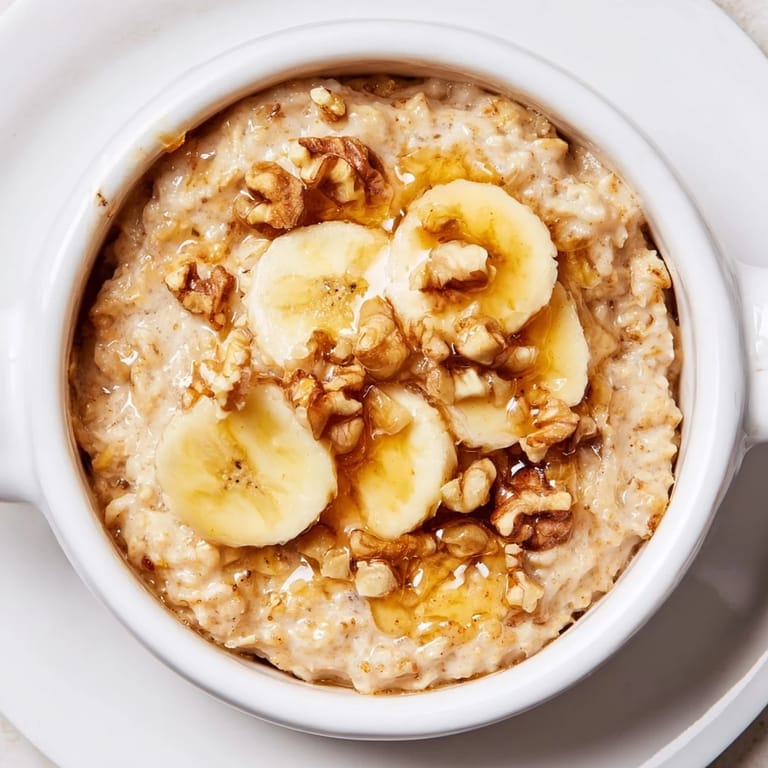 Individual ramekins of baked oats, a cozy breakfast with sliced banana and a honey glaze.
