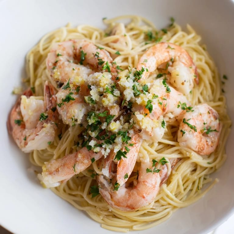 Tender shrimp and angel hair pasta glistening in a flavorful one-skillet Lemon Garlic Shrimp dish.