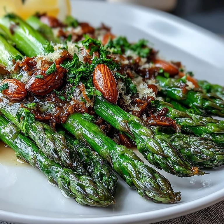 Tender asparagus in a lemony butter sauce, garnished with golden almonds for an elegant vegetable side.