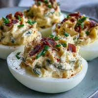 Creamy sweet pickle relish deviled eggs, a zesty appetizer with paprika garnish.